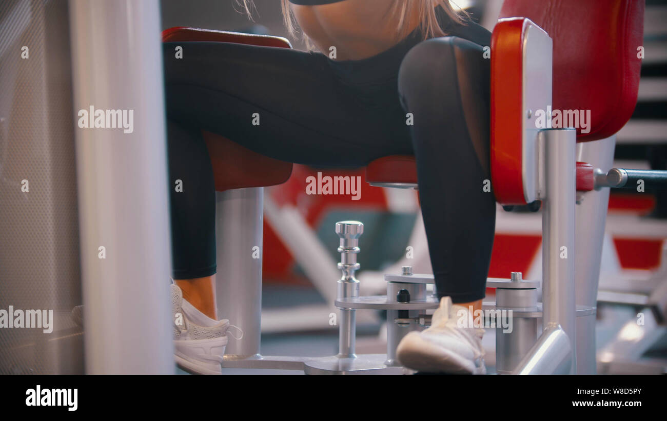 A woman training in the gym training her legs on the butterfly training apparatus Stock Photo Alamy