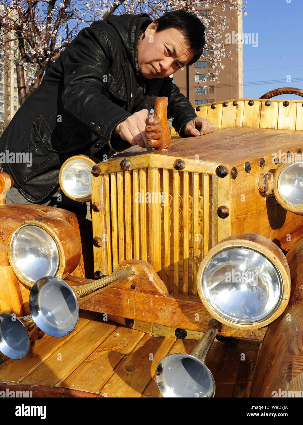 Chinese carpenter Liu Fulong dusts off the logo of his third homemade