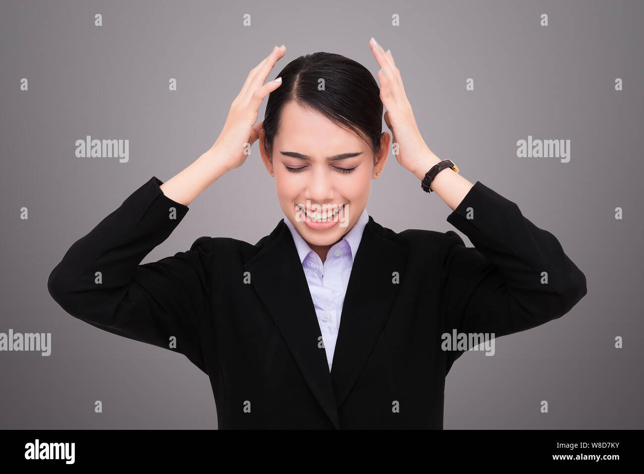 Young woman making a mistake on a gray background Stock Photo
