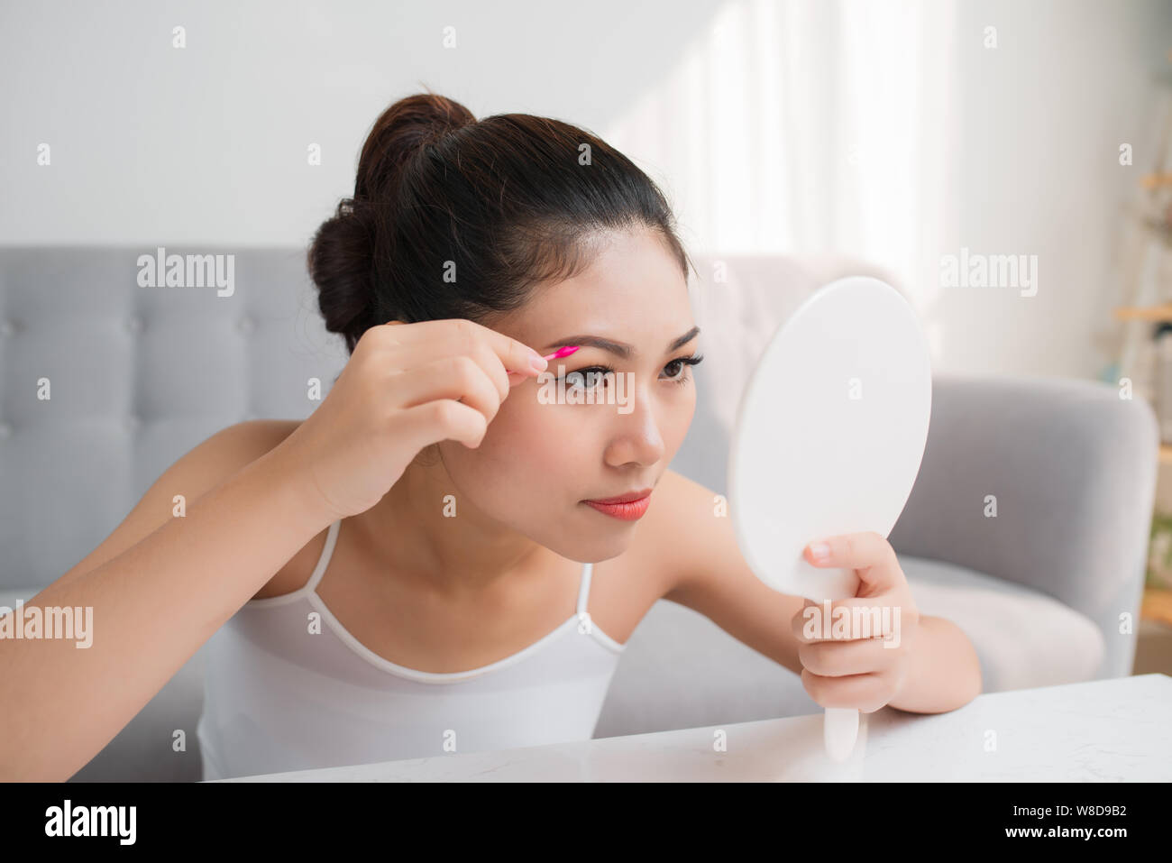Beautiful Asian woman with a cotton swab beside a her eye. Make up