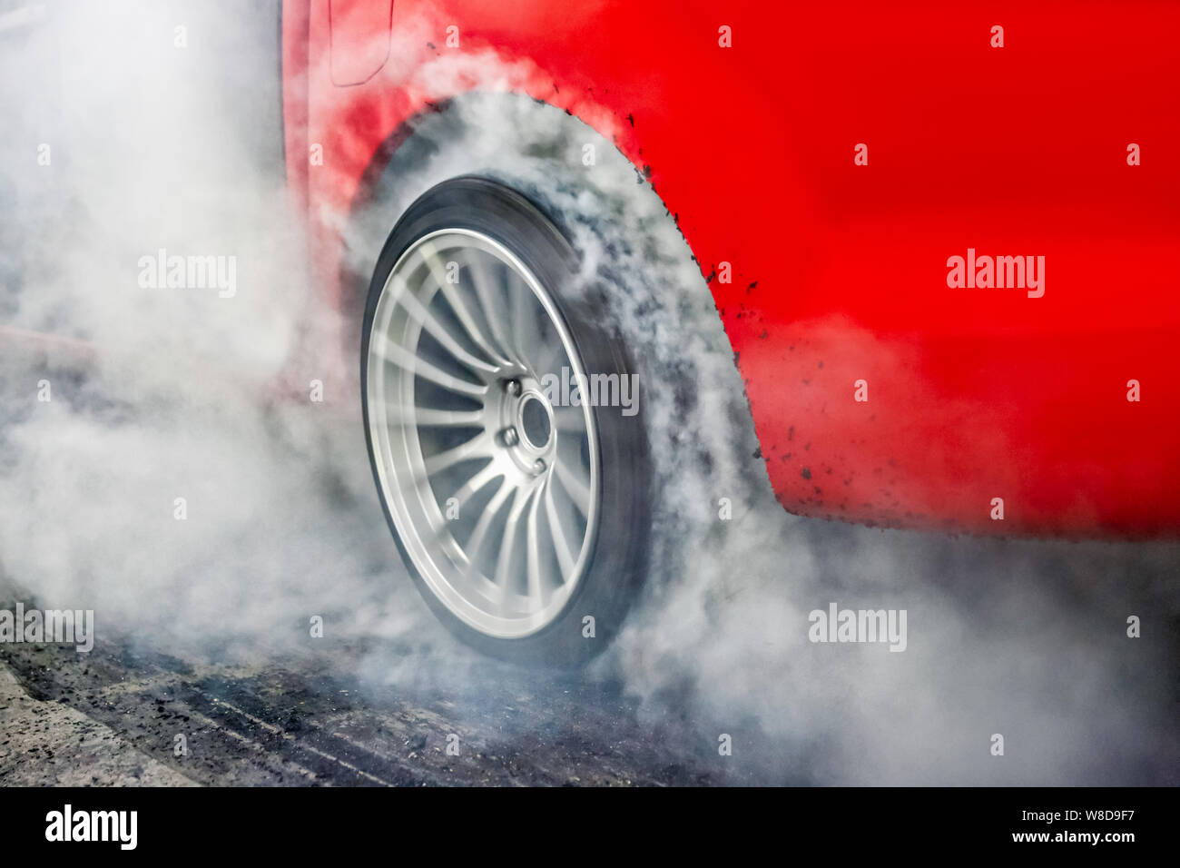 Drag racing car burns rubber off its tires in preparation for the race Stock Photo