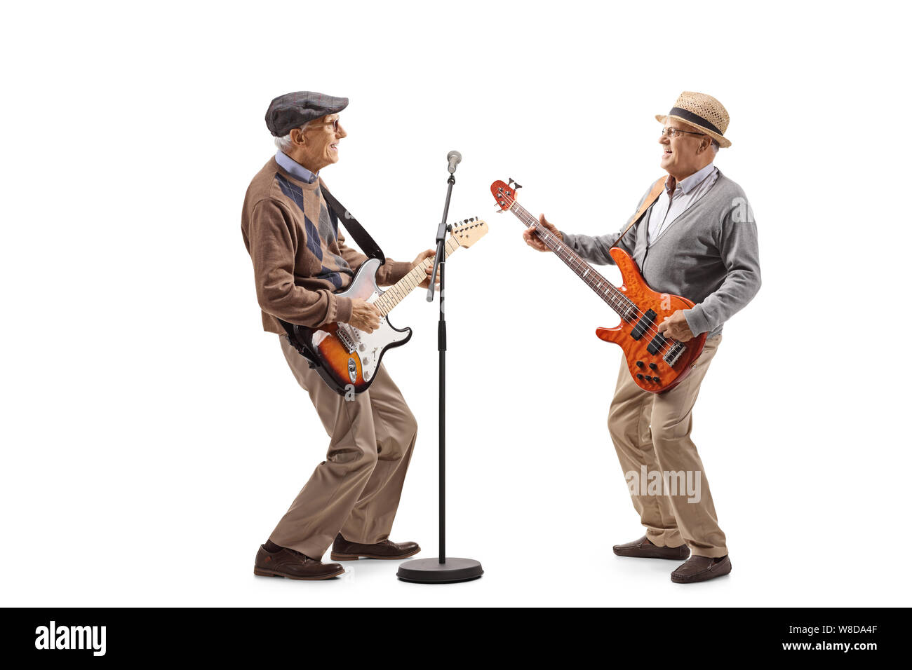 Full length shot of two elderly men having a jam session with electric guitars isolated on white background Stock Photo