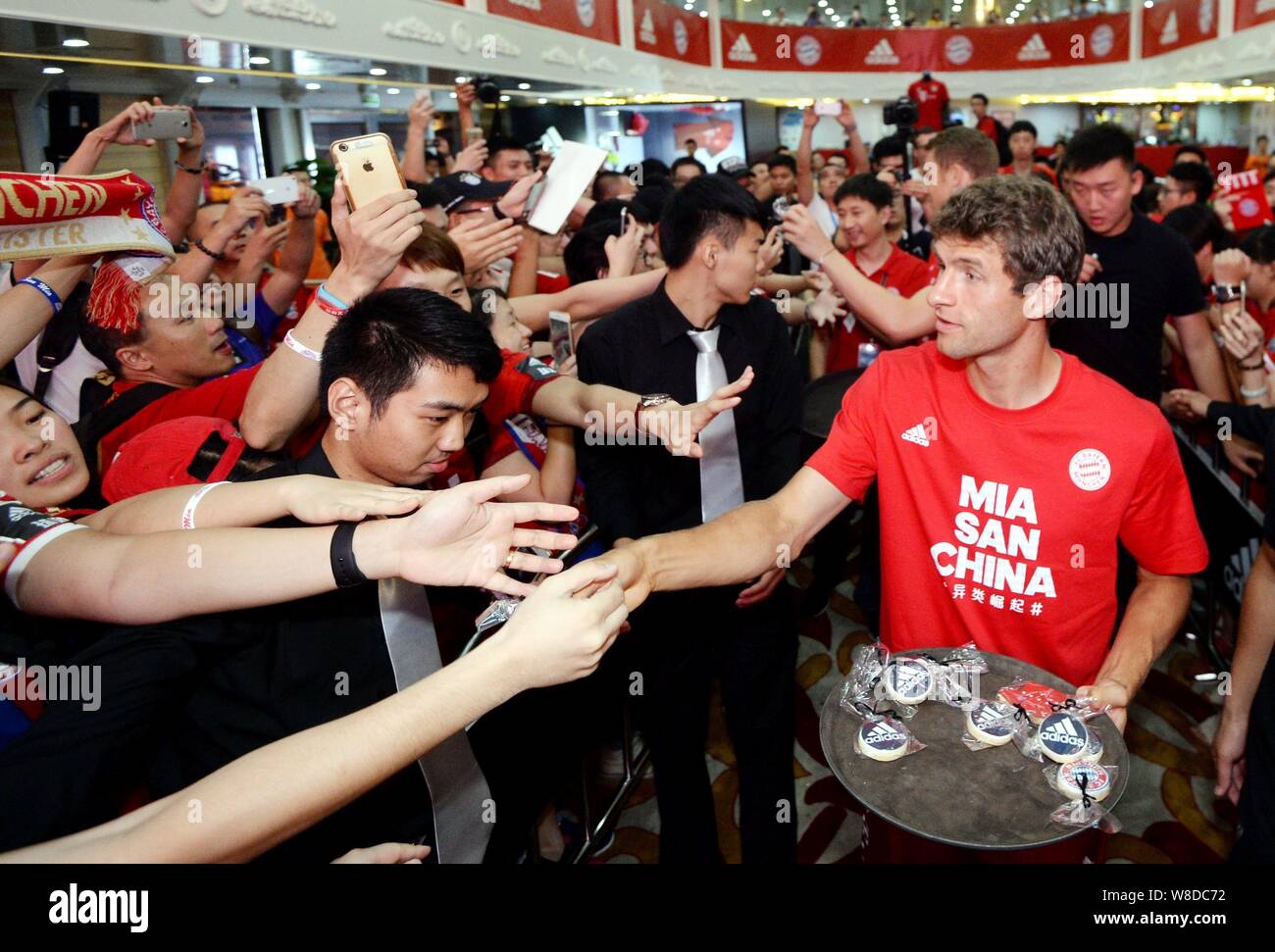 Thomas Mueller right of Bayern Munich distributes gifts to