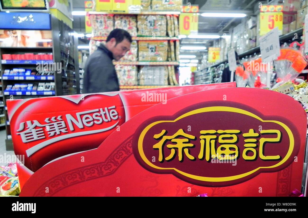 --FILE--A customer walks past counters of Nestle and Hsu Fu Chi at a supermarket in Hangzhou city, east China's Zhejiang province, 8 December 2011. Stock Photo