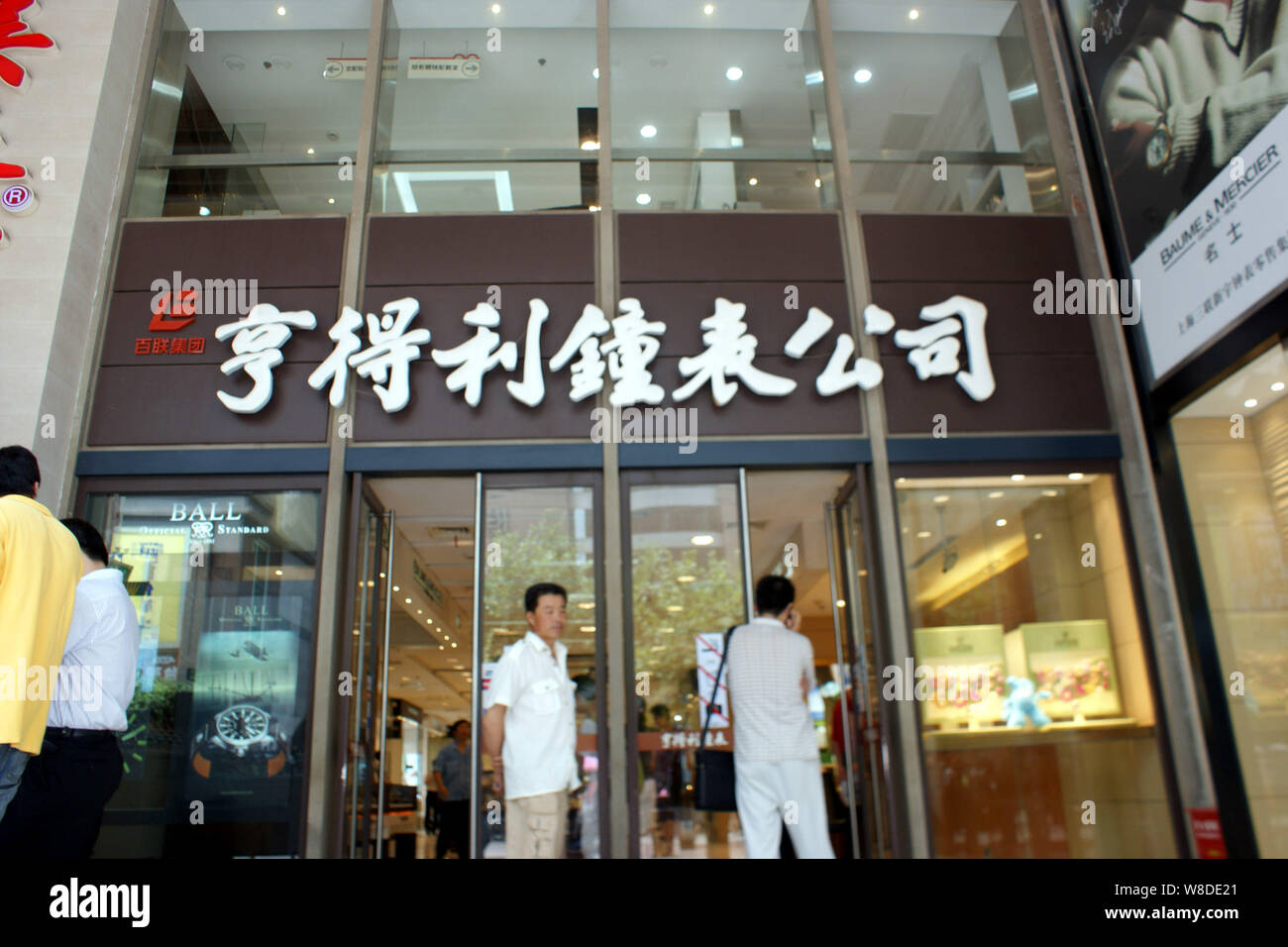 --FILE--Customers enter or leave a store of Hengdeli Clocks and Watches in Shanghai, China, 19 July 2009.   Luxury goods retailer Hengdeli Holdings is Stock Photo