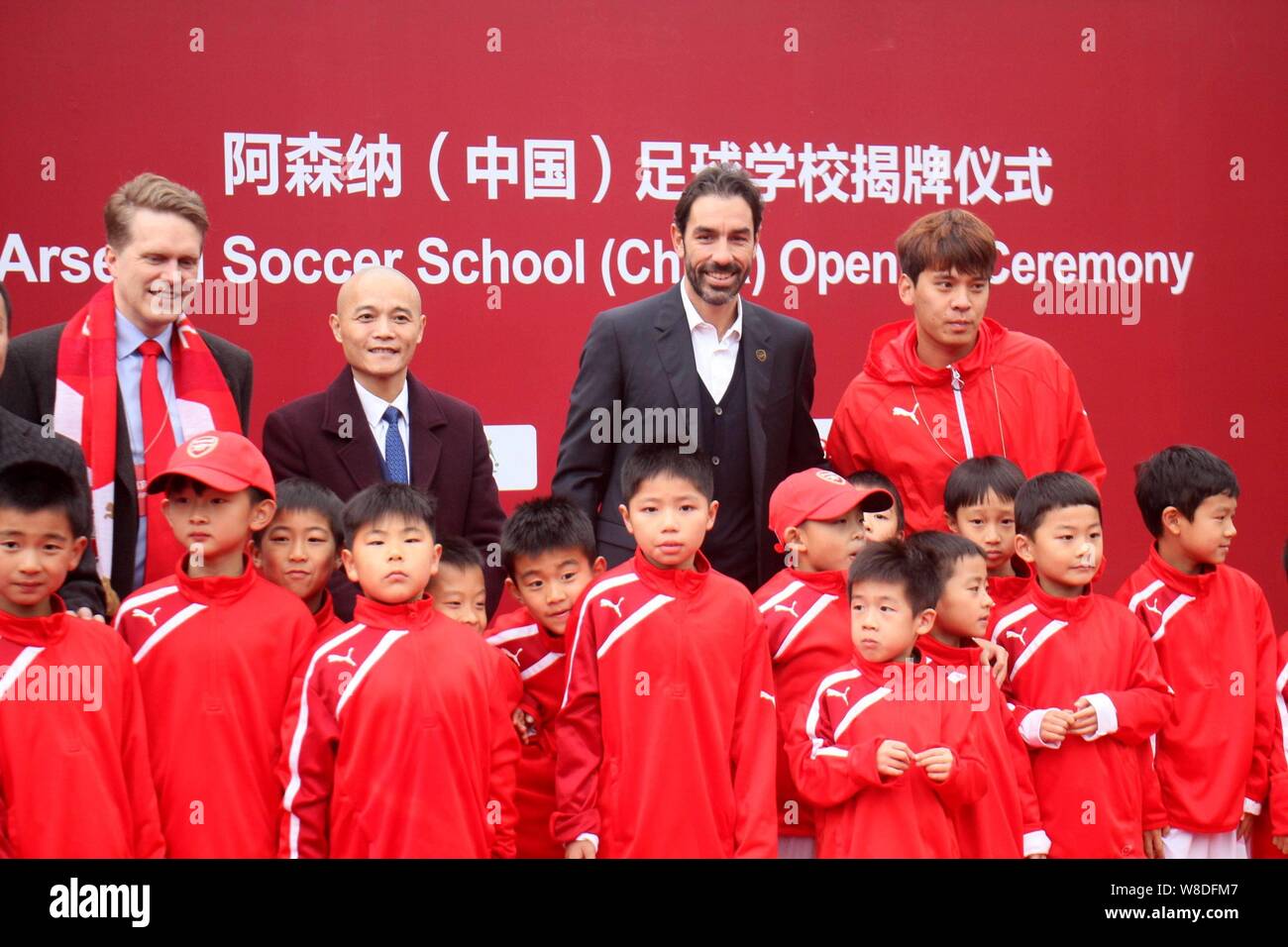 Retired French football player Robert Pires, back second right, poses with children during the opening ceremony of the Arsenal Soccer School (China) i Stock Photo