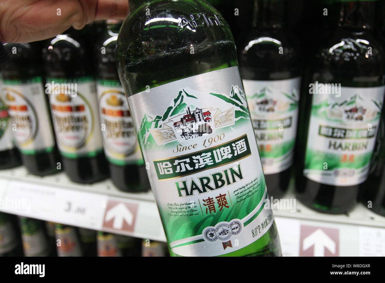 --FILE--A customer buys a bottle of Harbin beer of Anheuser-Busch InBev Group at a supermarket in Xuchang city, central China's Henan province, 2 Marc Stock Photo