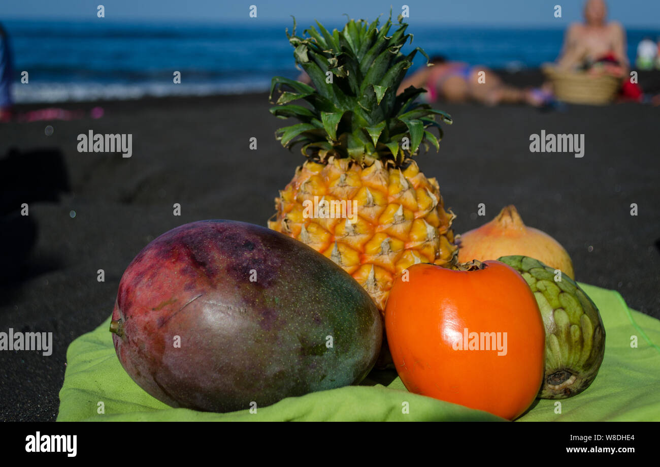 Exotic fruits on the black sand beach in Canary Islands. Mango