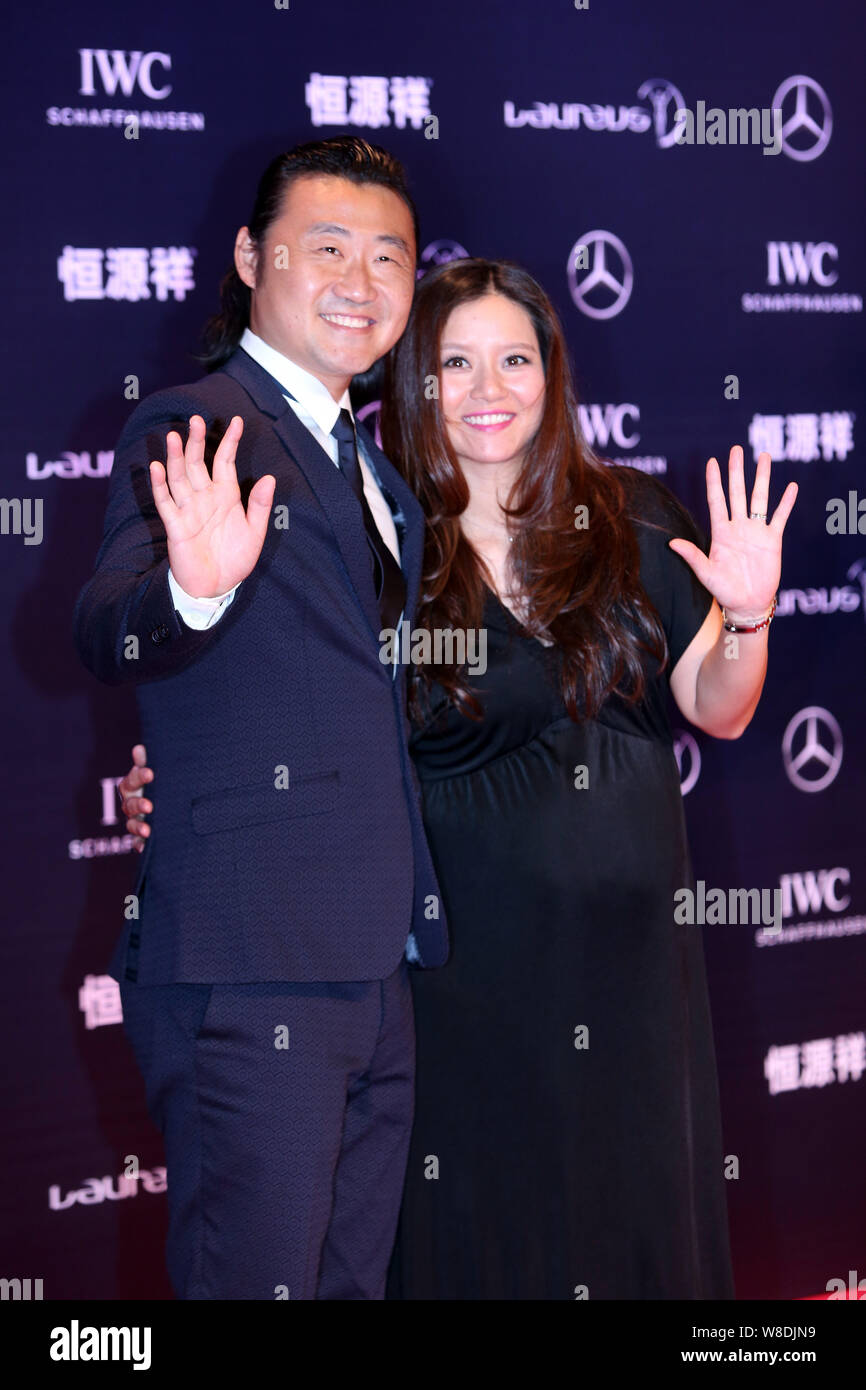 --FILE--Retired Chinese tennis star Li Na, right, and her husband Jiang Shan wave on the red carpet for the Laureus World Sports Awards Shanghai 2015 Stock Photo