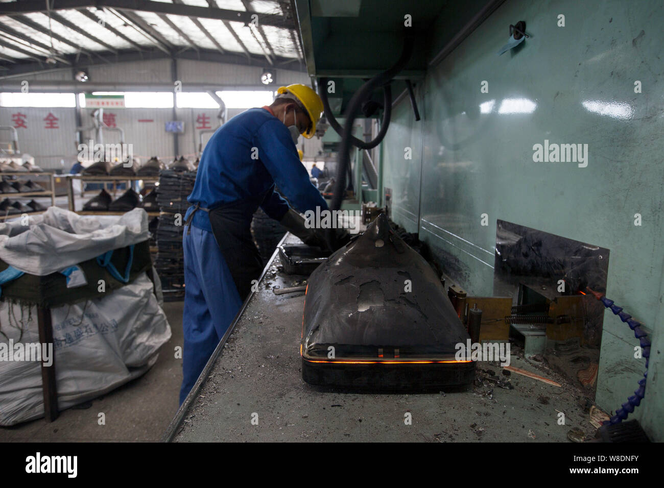 A Chinese worker disassembles tube television sets in a plant at the Miluo Circular Economy Industrial Park in Miluo city, central China's Hunan provi Stock Photo