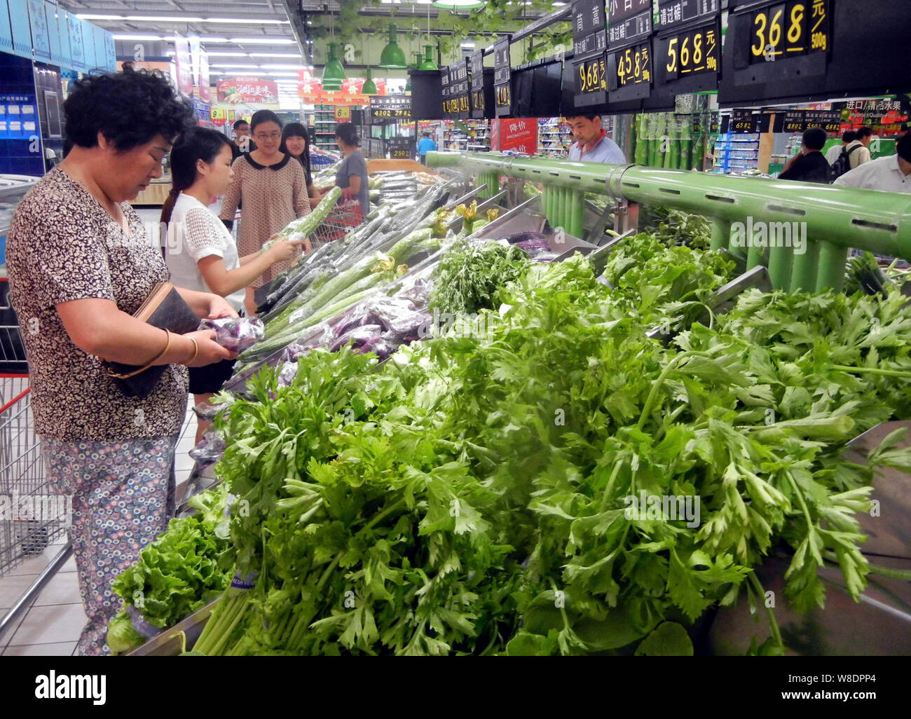 --FILE--Customers buy vegetables at a supermarket in Suzhou city, east China's Jiangsu province, 10 September 2015.    Chinas consumer confidence decl Stock Photo