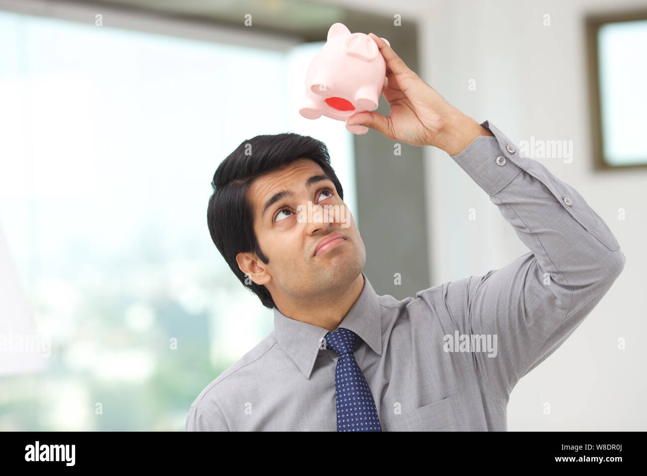 Businessman looking in an empty piggy bank Stock Photo - Alamy