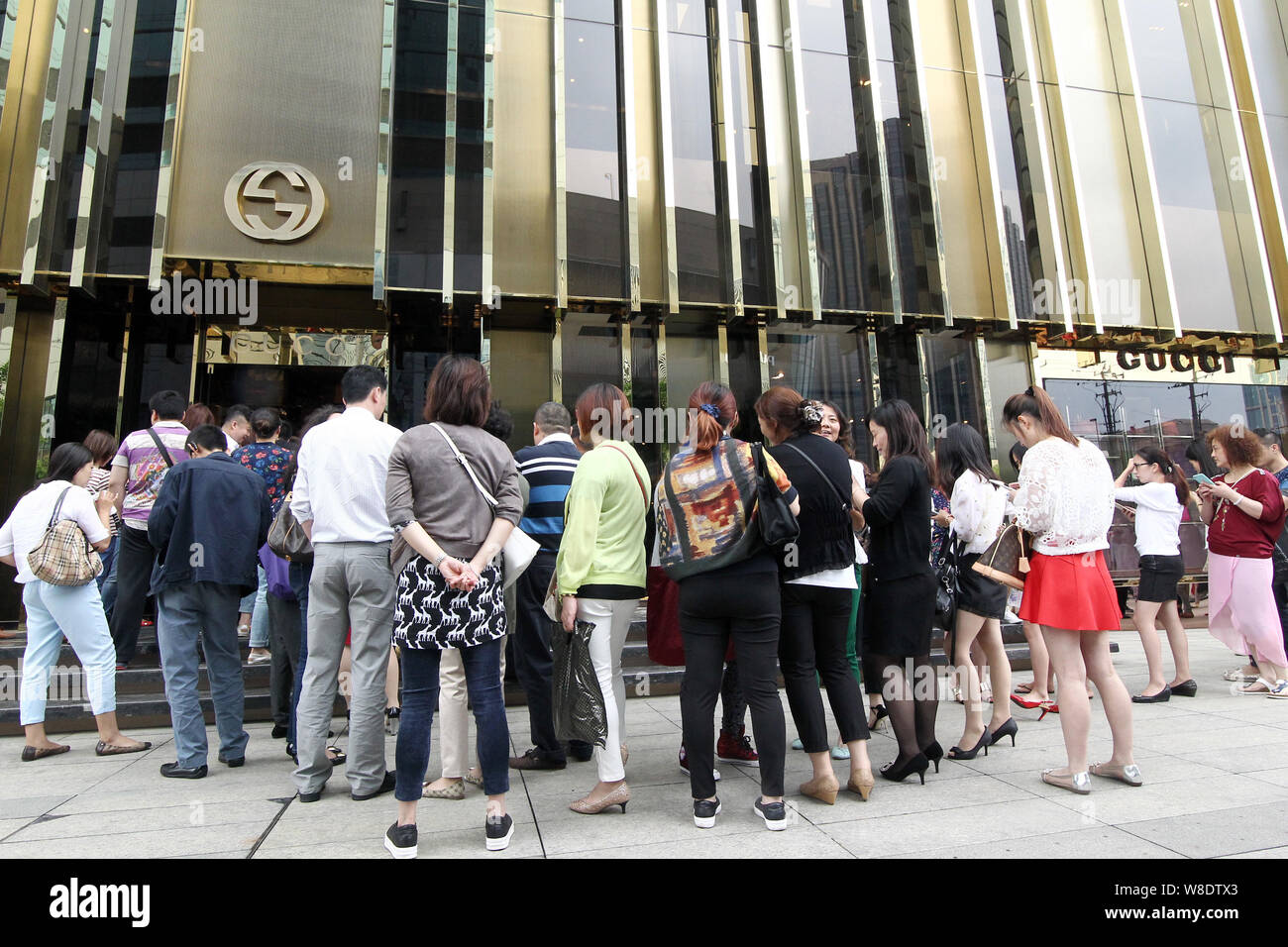 FILE--Chinese customers queue up outside a fashion boutique of Gucci after  the fashion house announced price cut in the China region in Shanghai, Ch  Stock Photo - Alamy
