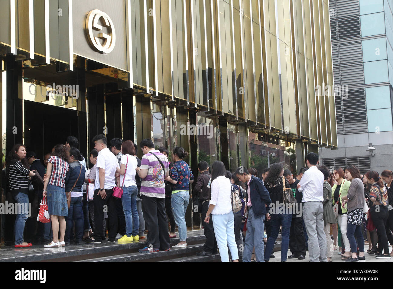 FILE--Customers queue up outside a Gucci boutique in Shanghai, China, 27  May 2015. Established luxury brands are facing a sales slowdown in China  Stock Photo - Alamy