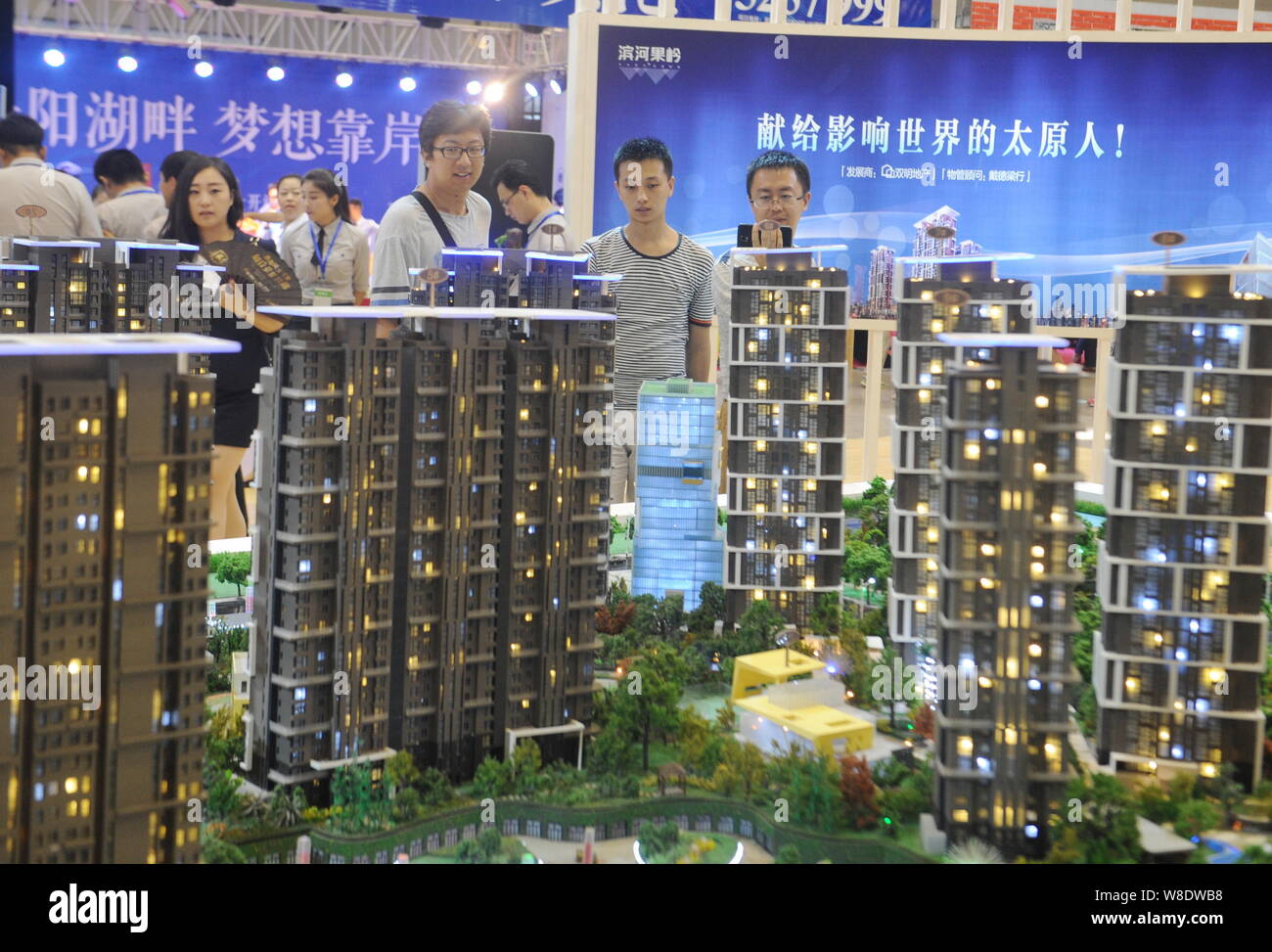 --FILE--Chinese homebuyers look at housing models of a residential property project at a real estate fair in Taiyuan city, north China's Shanxi provin Stock Photo