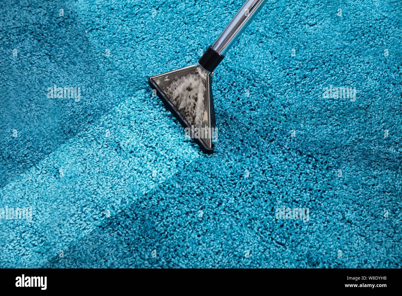 Close-up Of A Person Cleaning Carpet With Vacuum Cleaner Stock Photo