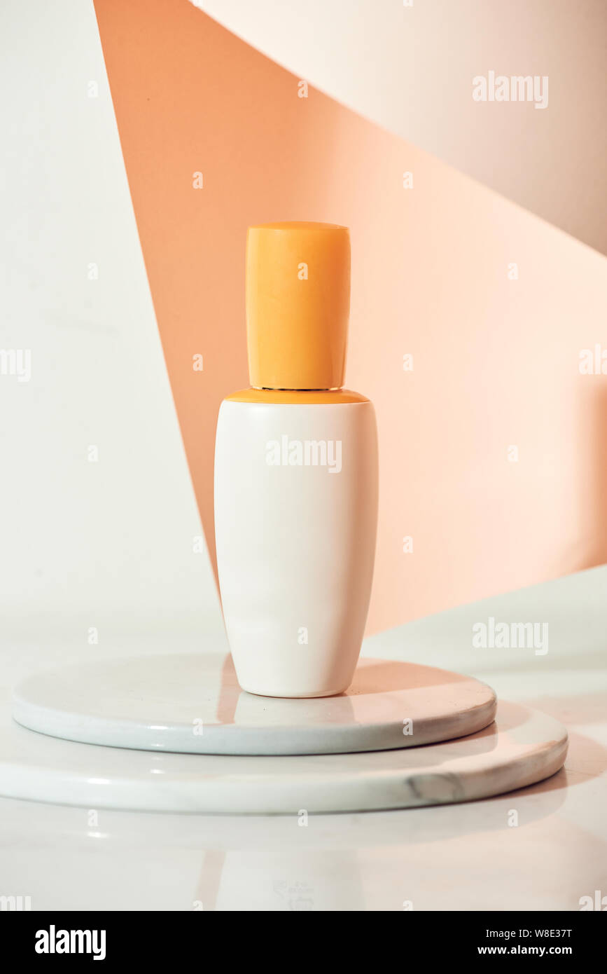 Skincare product serum bottle mockup sample styling on beige table with pink paper. Product studio styling shot Stock Photo