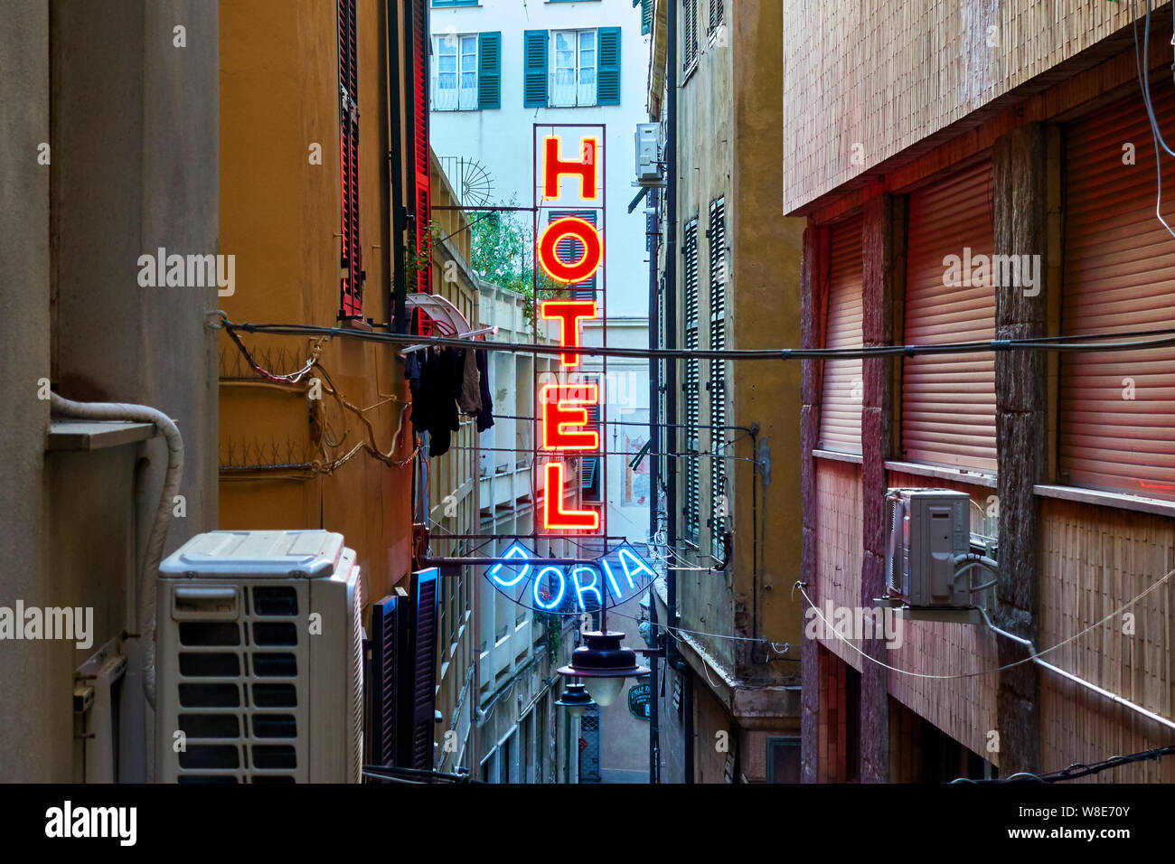 Genoa (Genova), Italy - June 30, 2019: Red neon hotel sign on the wall in the narrow street in Genoa Stock Photo