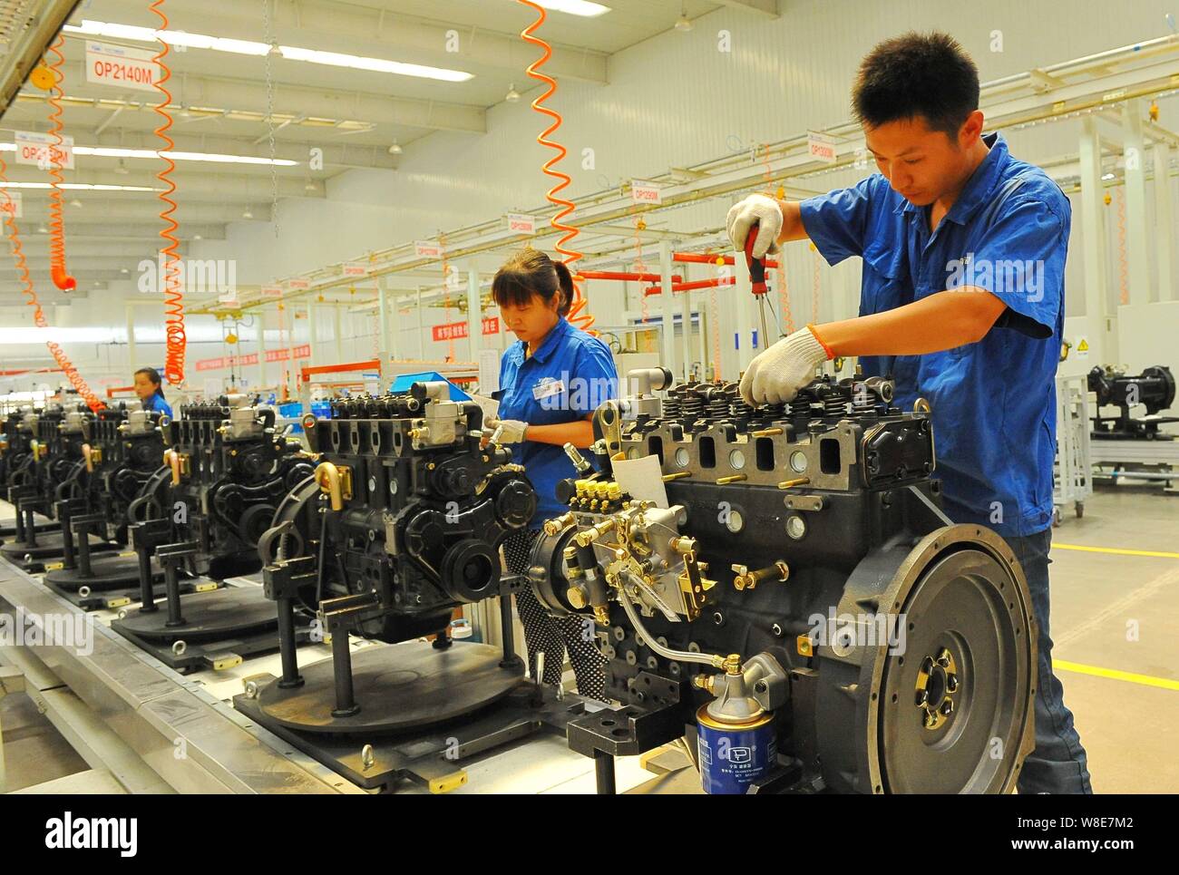 --FILE--Chinese workers assemble engines on the assembly line at an ...