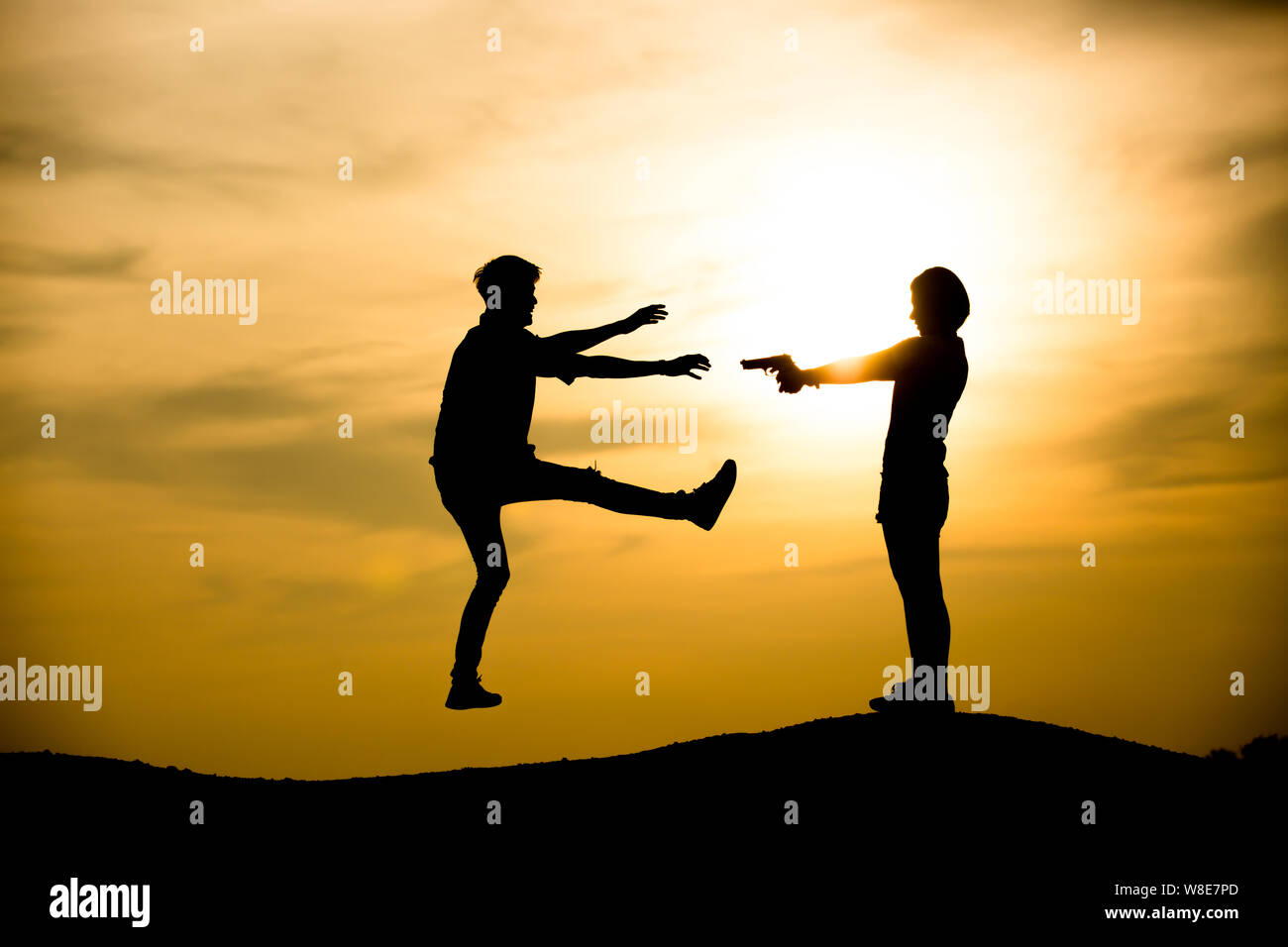 Silhouette woman pointing at the man on the sunset background Stock Photo