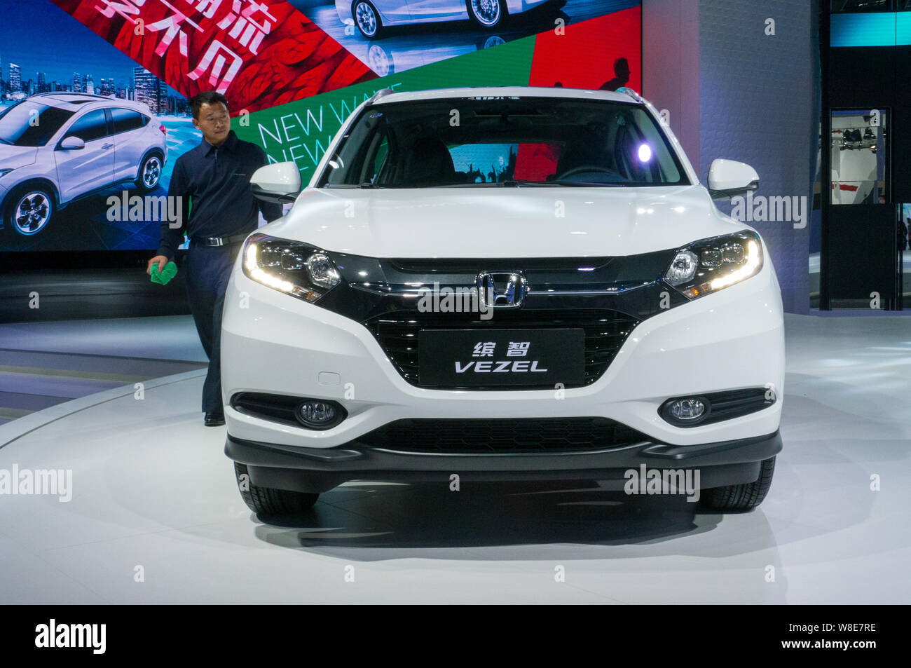 --FILE--A Chinese employee walks past a Honda VEZEL during the 12th China (Guangzhou) International Automobile Exhibition, also known as Auto Guangzho Stock Photo