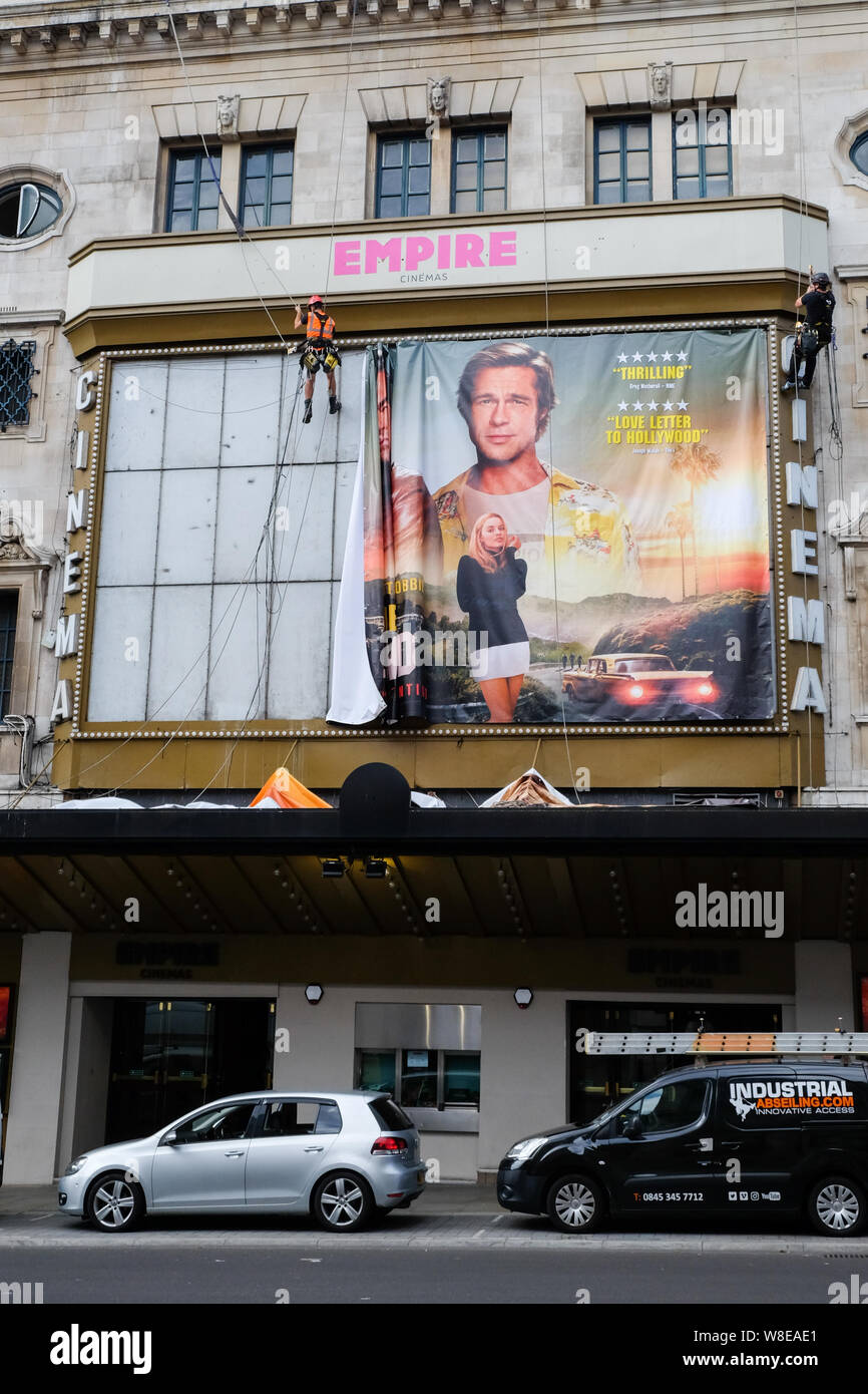 Haymarket, London, UK. 9th August 2019. Workmen installing a poster for the new Quentin Tarantino film Once Upon a Time In Hollywood. above the Empire cinema. Credit: Matthew Chattle/Alamy Live News Stock Photo