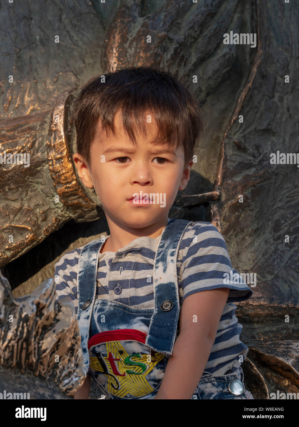 Boy at statue of Nasreddin, Historic City of Bukhara, Uzbekistan, Asia Stock Photo