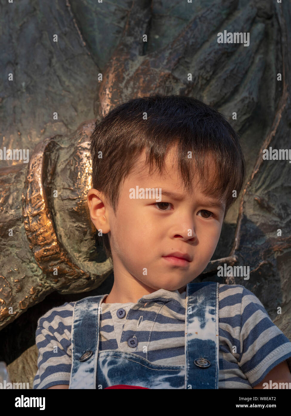 Boy at statue of Nasreddin, Historic City of Bukhara, Uzbekistan, Asia Stock Photo