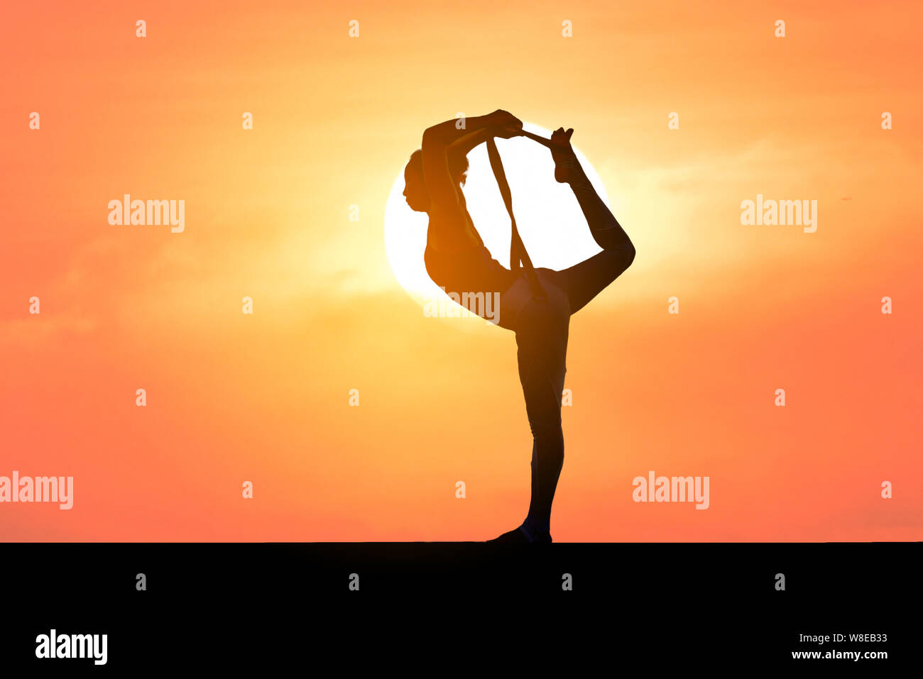 woman practice yoga on mountain with sunset or sunrise background Stock Photo