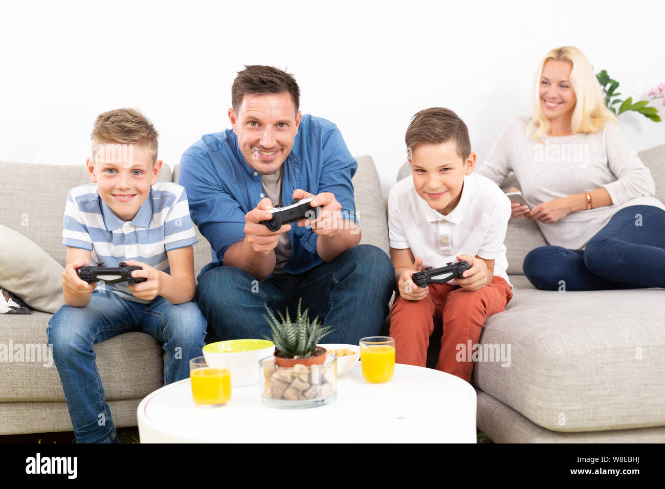 Happy young family playing videogame On TV. Stock Photo