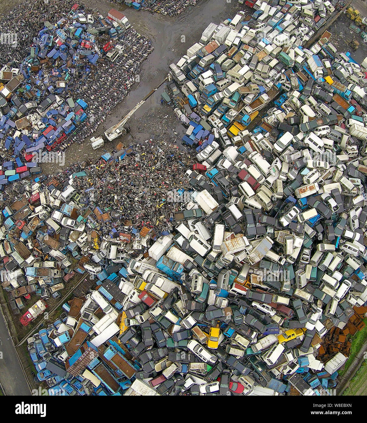 Aerial view of a junkyard piled high with scrapped vehicles in Hangzhou