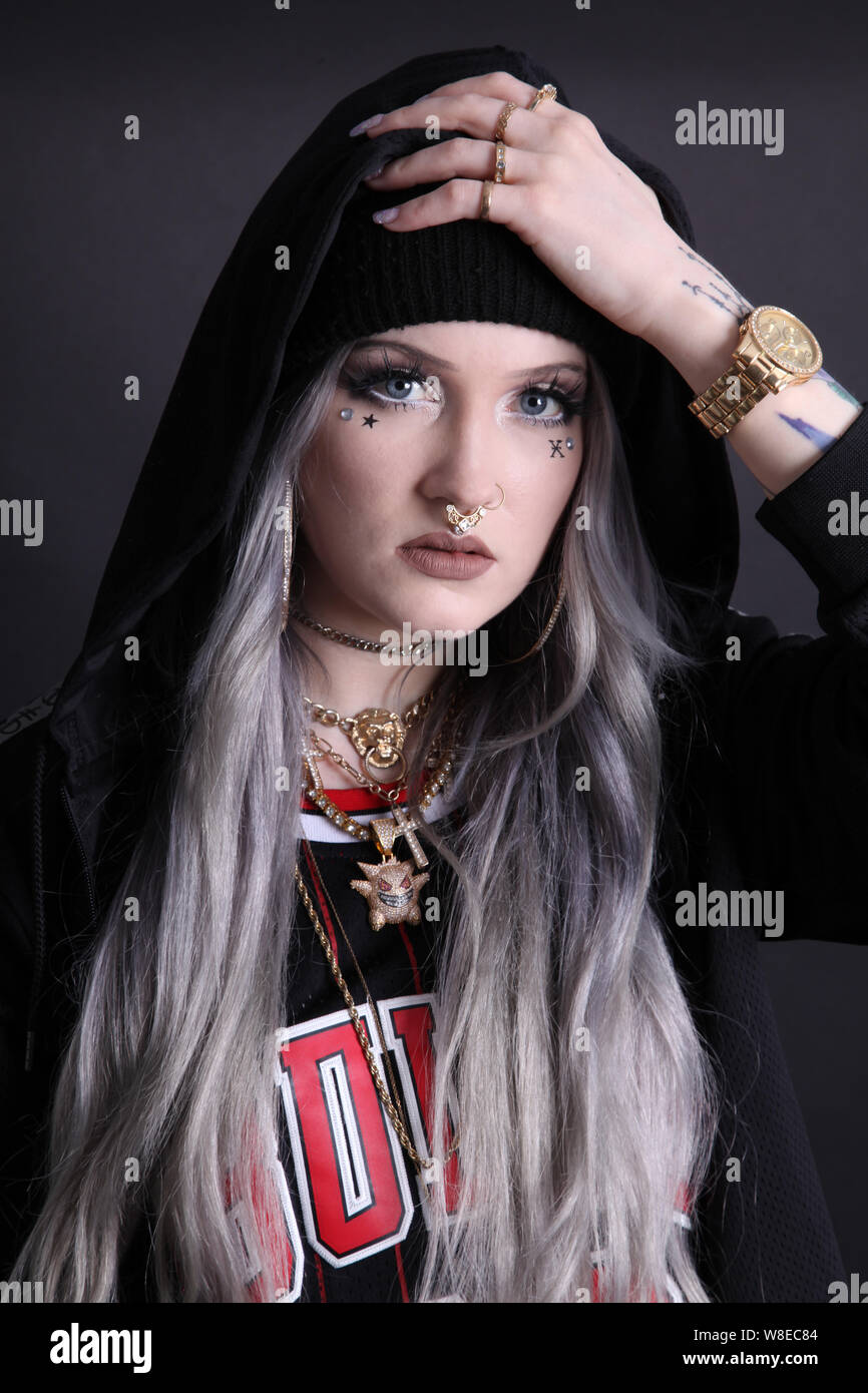 Female Millennial in hoodie holding head showing emotion, having problems, mental health, cyber bullying, life issues, worried, portrait Stock Photo