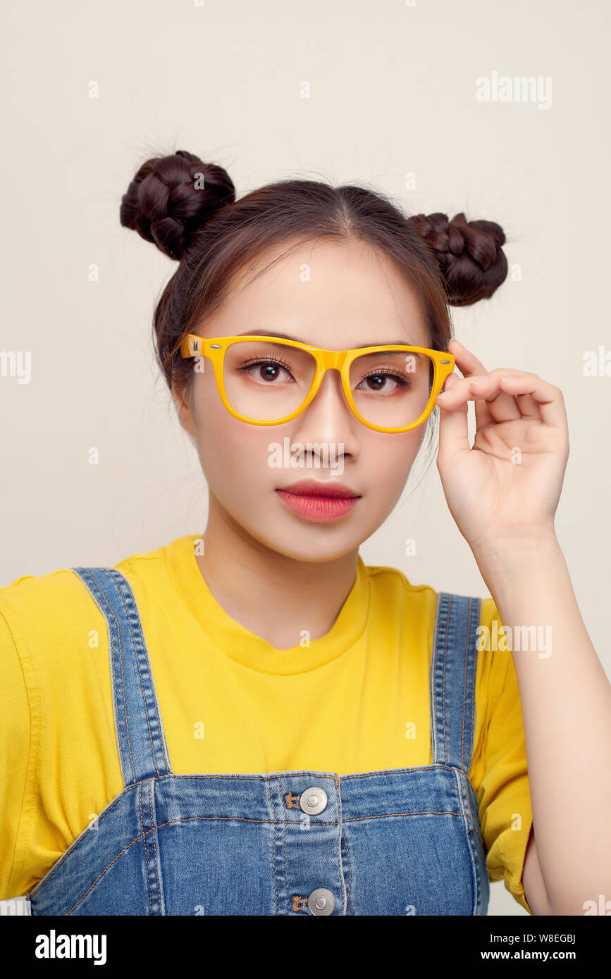Portrait Of Asian Holding Her Glasses With Two Hair Buns Wear A