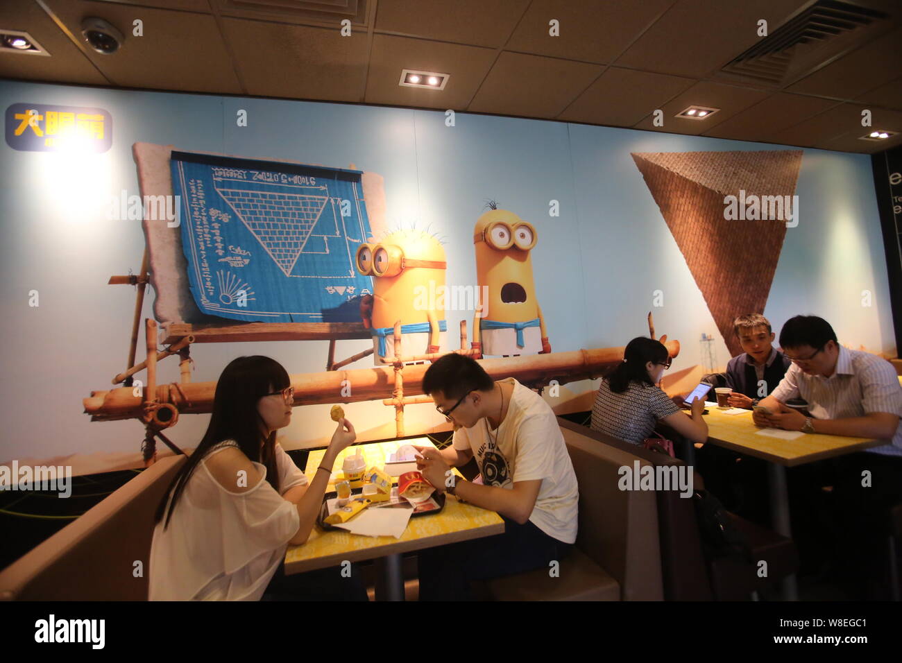 Customers eat at a Minions-themed McDonald's fastfood restaurant in  Shanghai, China, 2 July 2015. The Minions from Universal Pictures and  Illuminati Stock Photo - Alamy, image size:1300x956