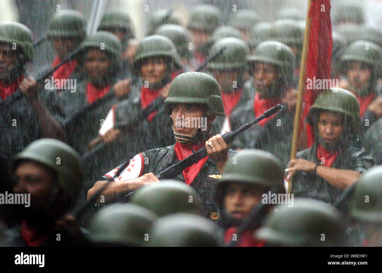 Venezuelan reservists hold AK-47 Kalashnikov rifles in the rain during a parade with Venezuelan President Hugo Chavez in Caracas, Venezuela Stock Photo