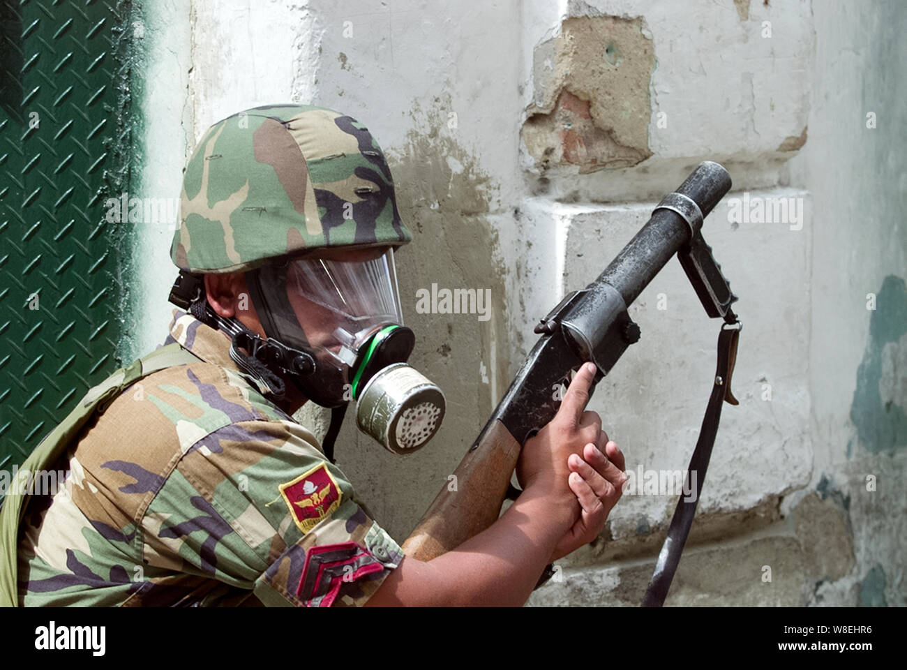 A national guard wearing a gas mask holds a tear gun launcher in Caracas, Venezuela Stock Photo