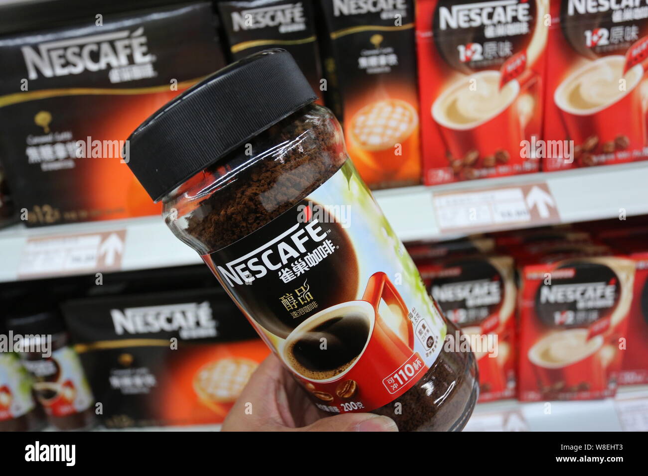 --FILE--A customer buys a bottle of Nescafe instant coffee of Nestle at a supermarket in Xuchang city, central Chinas Henan province, 7 December 2014. Stock Photo