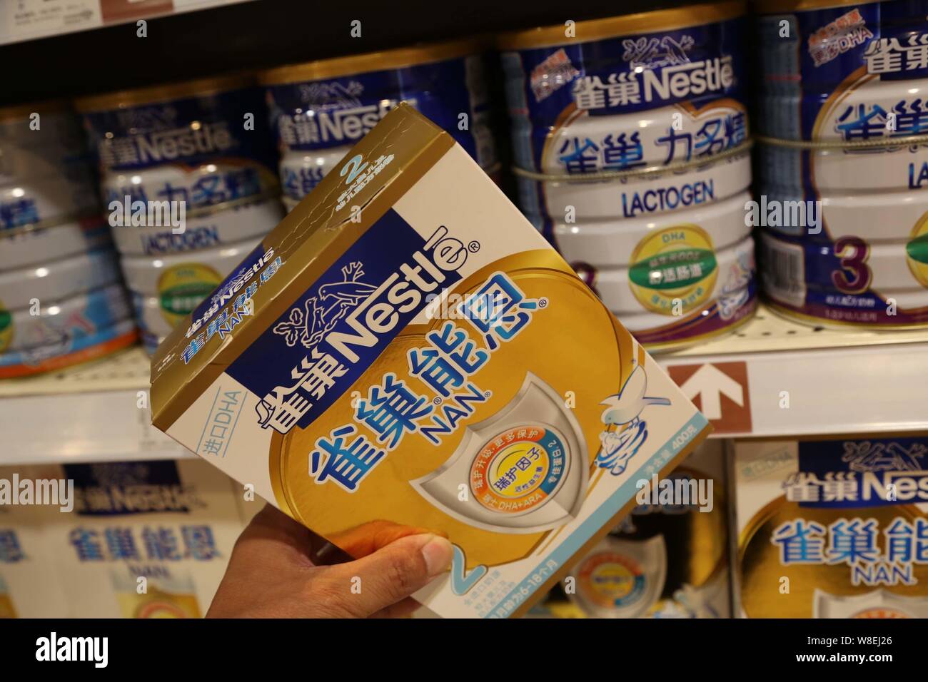 --FILE--A customer shops for a carton of Nestle infant formula at a supermarket in Xuchang city, central China's Henan province, 8 June 2014.   Nestle Stock Photo