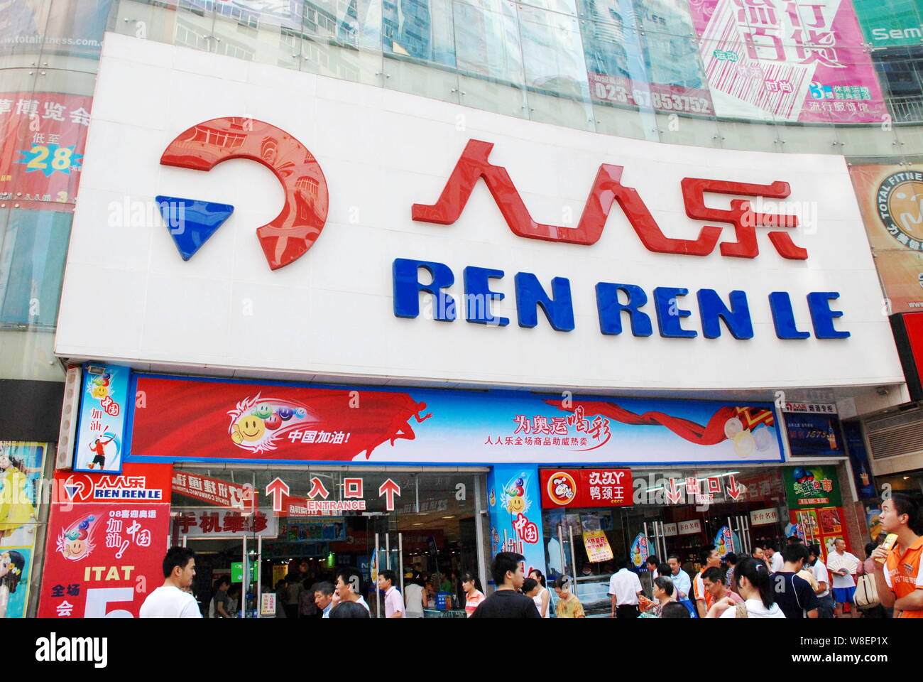 --FILE--Pedestrians walk past a supermarket of Ren Ren Le in Chongqing, China, 27 July 2008.   Shenzhen-based retail chain Ren Ren Le recently closed Stock Photo