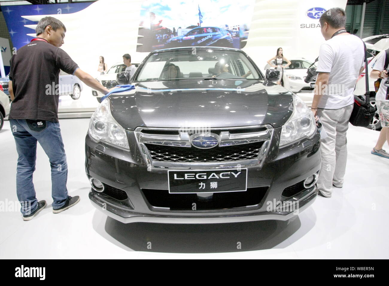 --FILE--Visitors try out or look at a Subaru Legacy on display during the 2014 Pudong International Automotive Exhibition, also known as Auto Pudong 2 Stock Photo