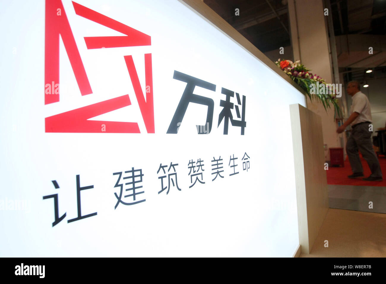 FILEA visitor walks past the stand of Vanke during a real estate