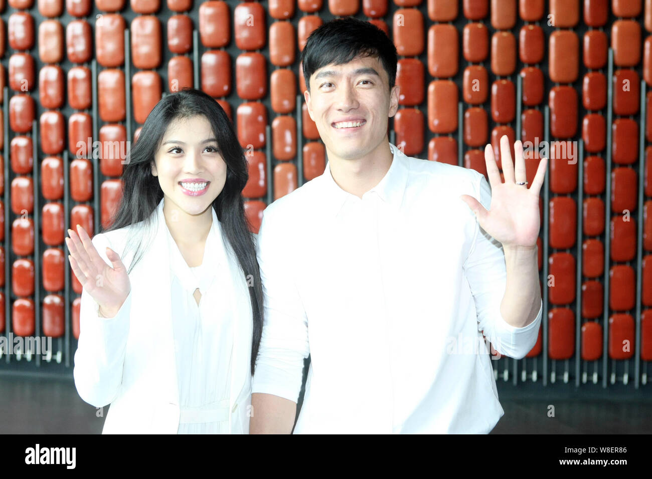 --FILE--Former Chinese star hurdler Liu Xiang, right, and his actress wife Ge Tian wave as they arrive at the ticket donation ceremony for St. Petersb Stock Photo