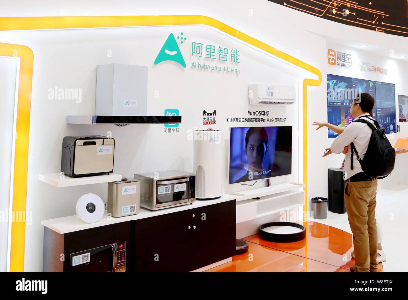 A visitor inquires an employee about Alibaba Smart Living during the GSMA Mobile World Congress 2015 in Shanghai, China, 15 July 2015. Stock Photo