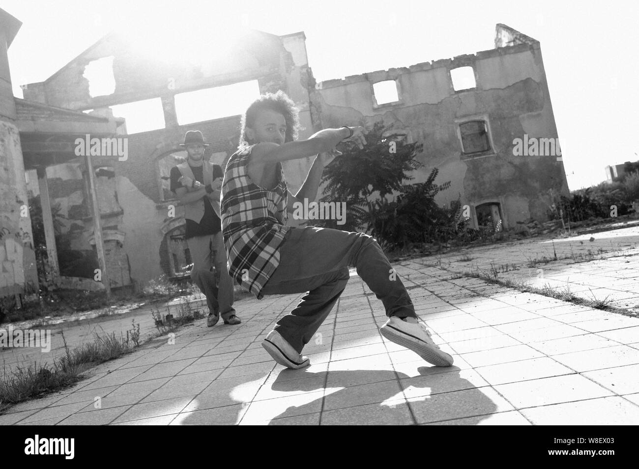 Young African American man hip hop dancing in an urban square with a ...