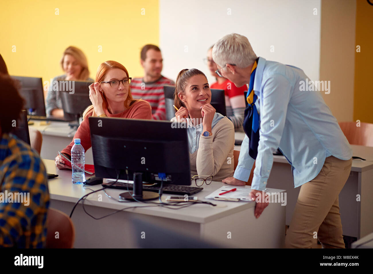 lecturer helping smiling students on project Stock Photo