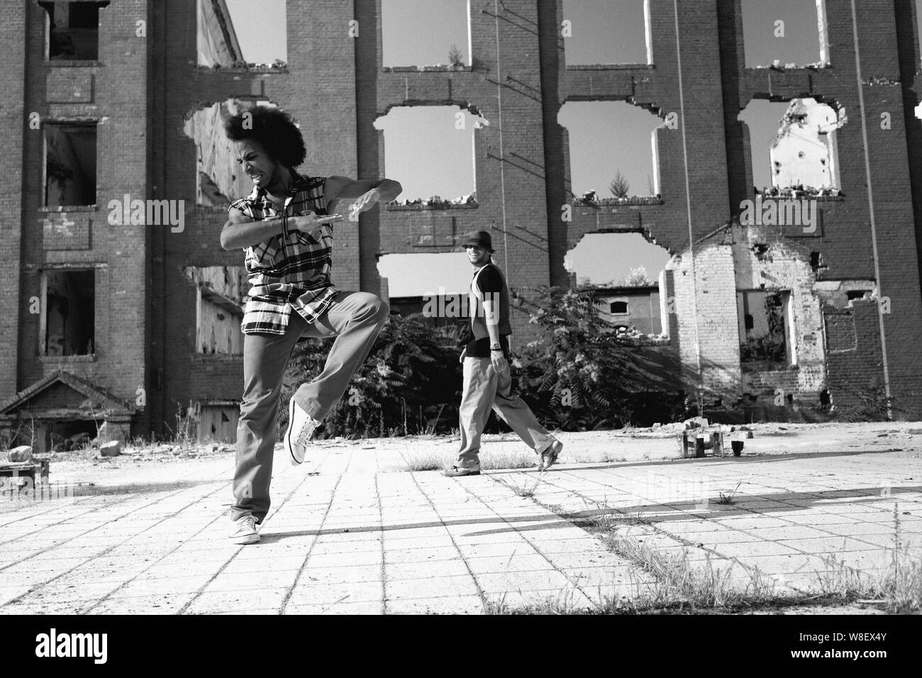 Young African American man hip hop dancing in an urban square with a ...