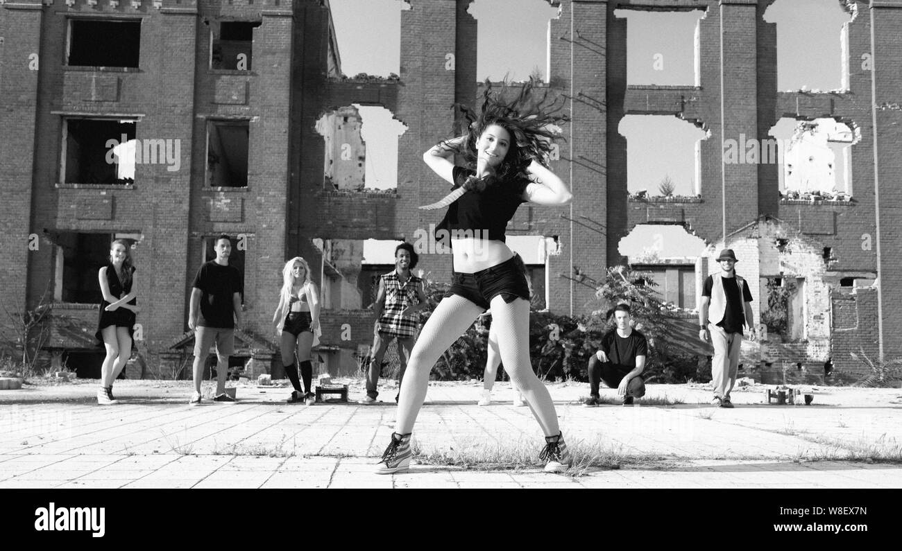 Young Girl hip hop dancing in an urban square with her friends ...