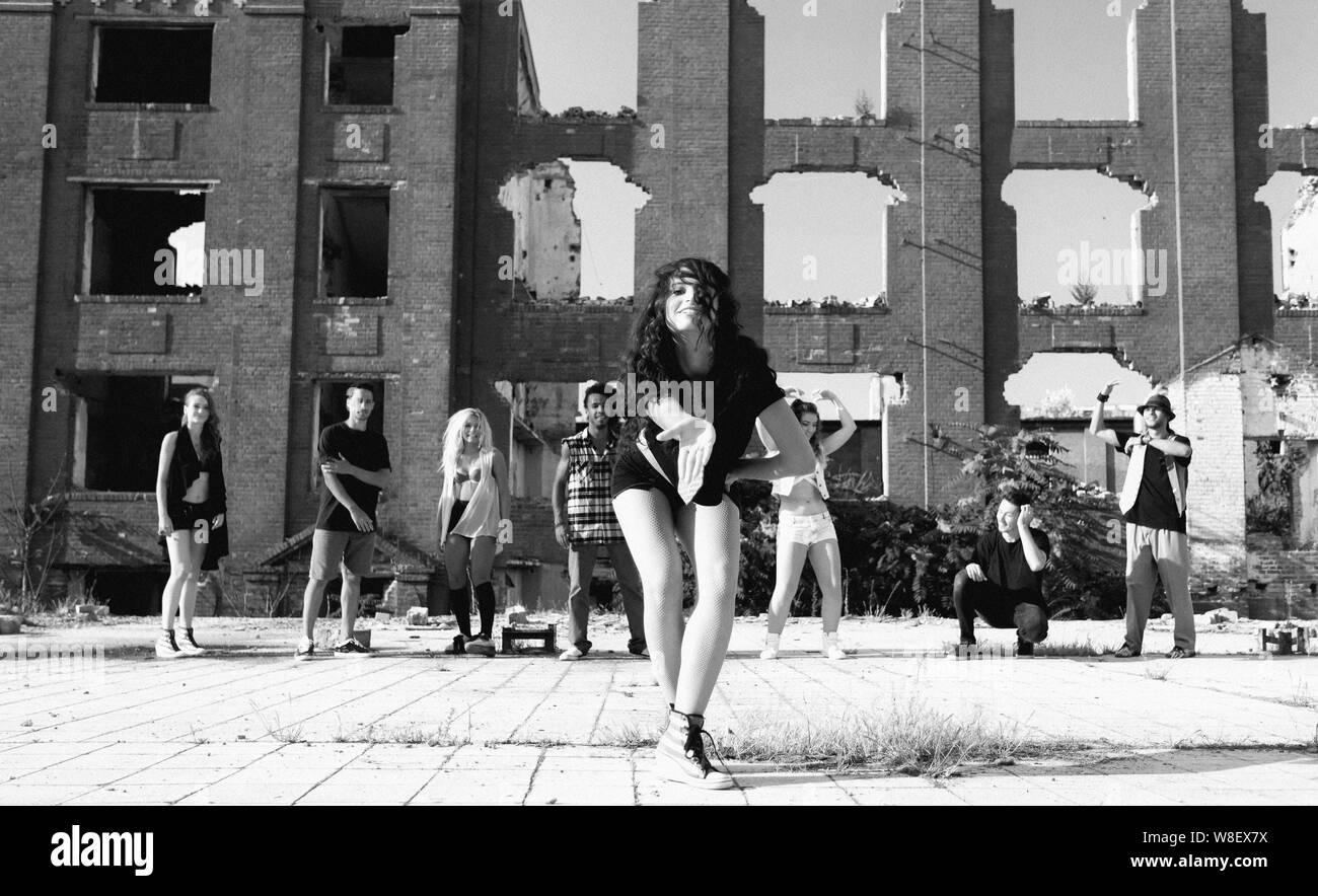 Young Girl hip hop dancing in an urban square with her friends ...