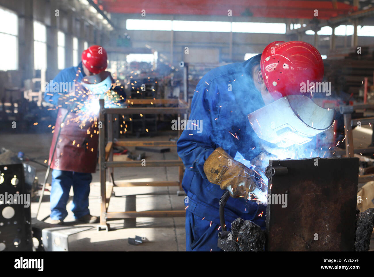 FILE--Chinese workers process auto parts at a factory in Rizhao city,  east China's Shandong province, 3 June 2015. Growth in Chinas industrial  Stock Photo - Alamy