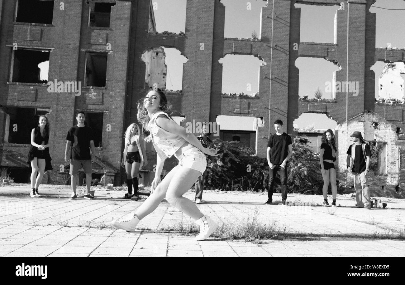 Young Girl hip hop dancing in an urban square with her friends ...